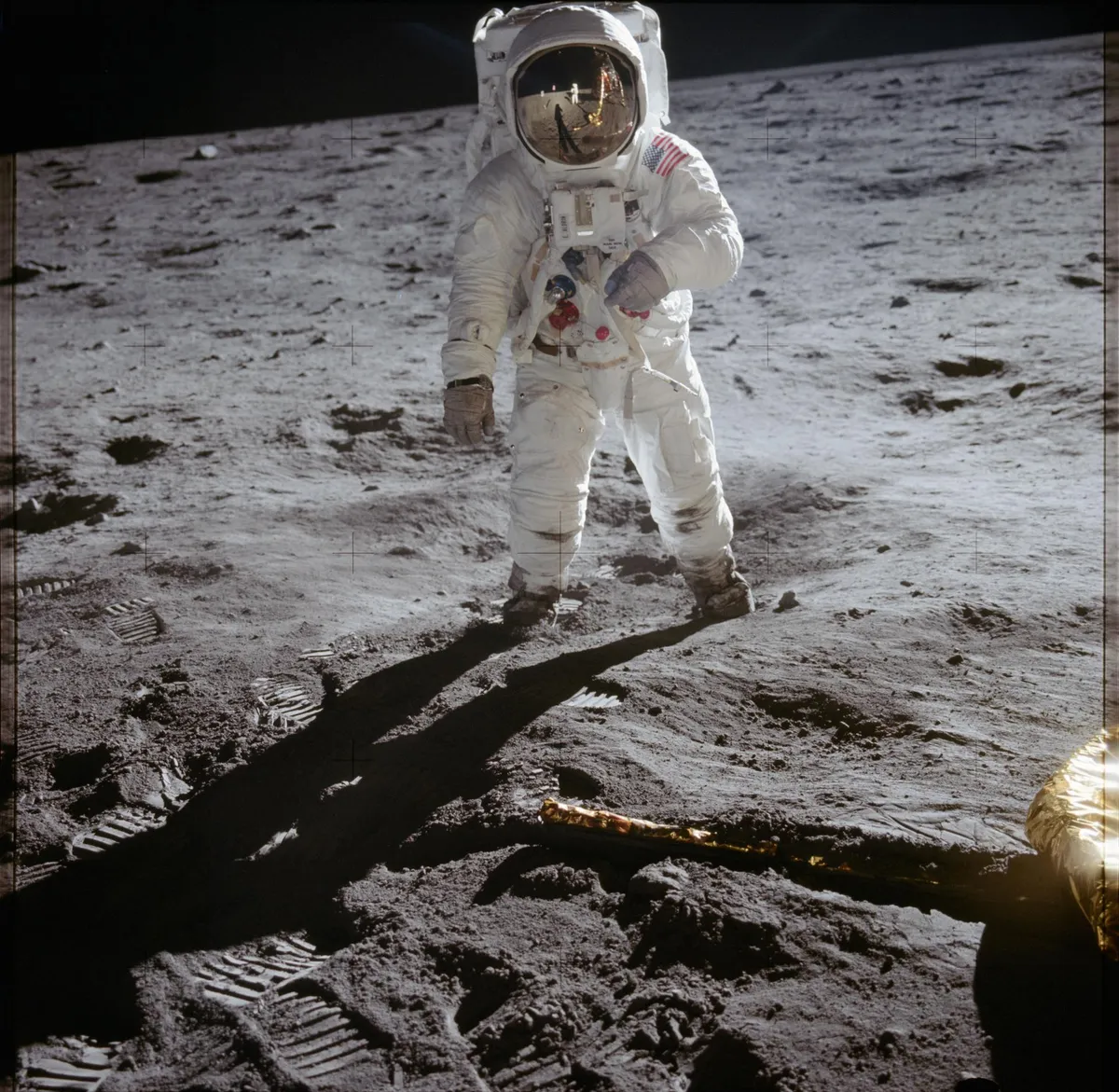 Ay yüzeyinde yürüyen, uzay giysili astronot ve ayak izleri